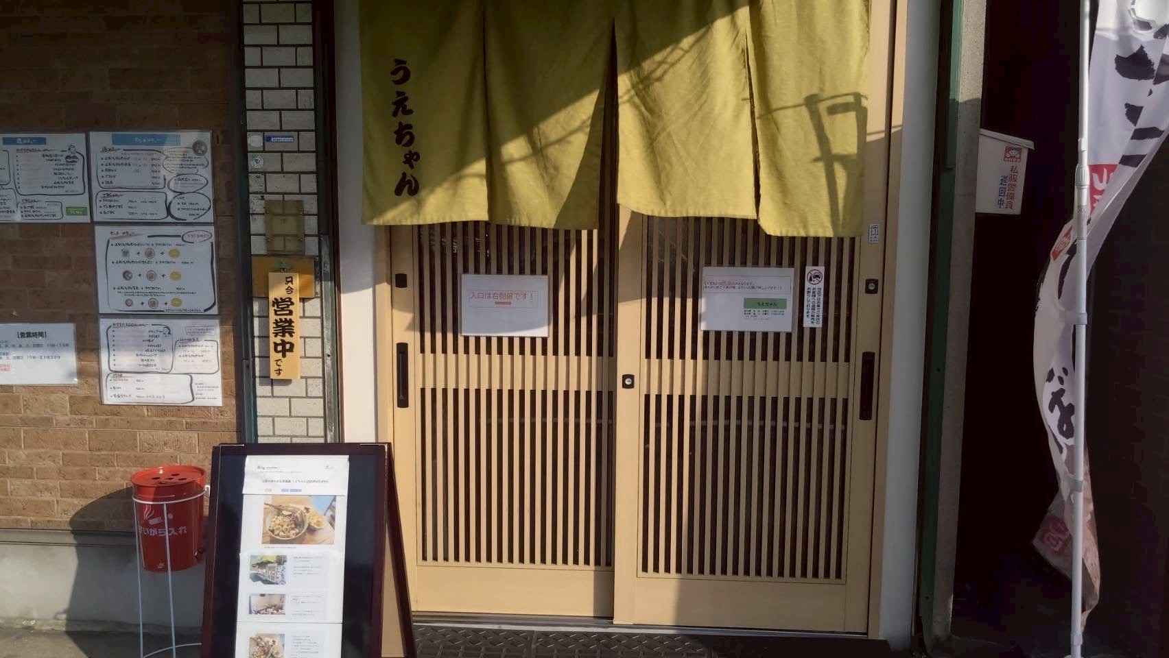 『うえちゃん』と書かれた黄緑ののれんが掛かる店舗入口