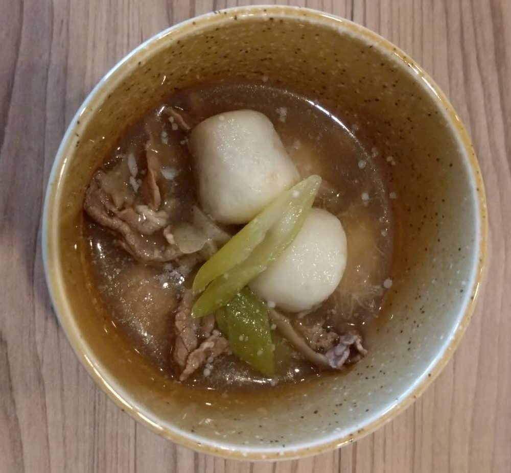 山形の芋煮。里芋と牛肉が入った温かい汁物で、湯気が立ちのぼるような一杯