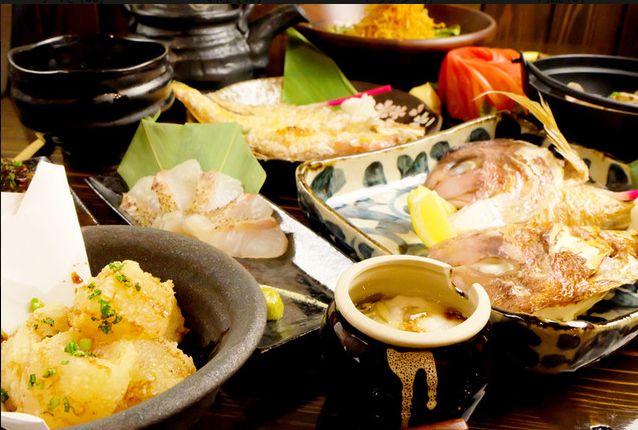 店内で宴会や飲み会を楽しむ場面をイメージできる料理写真で、複数人で利用できる宴会コースや鍋コースの案内として使われているメインビジュアル