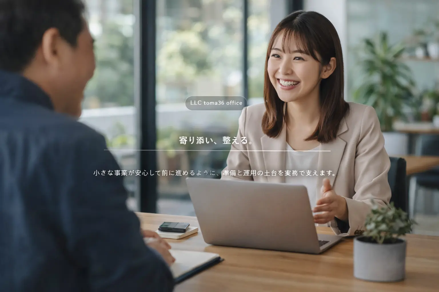 明るいオフィス空間で、若い女性スタッフが顧客と笑顔で会話しながら相談を進めている様子。安心感と前向きな未来を感じさせるヒーロー画像